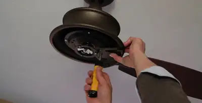 Electrician installing ceiling fan mounting bracket and fixture in Miami, FL