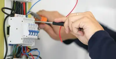 Electrician installing and adjusting circuit breakers in an electrical panel in Miami, FL