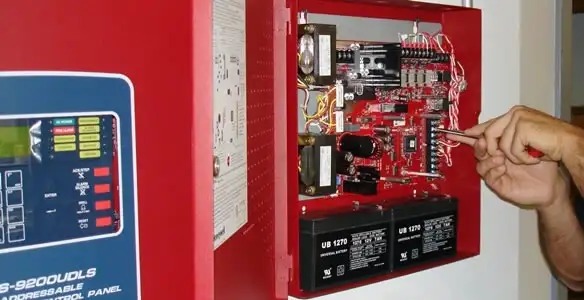 fire alarm installation service showing technician configuring fire alarm control panel in Miami, FL