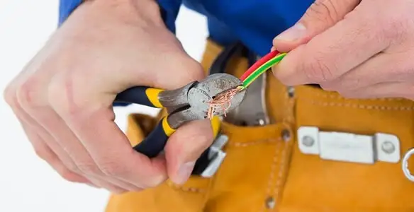 licensed electrician securing electrical wiring with professional tools during service work in Miami, FL
