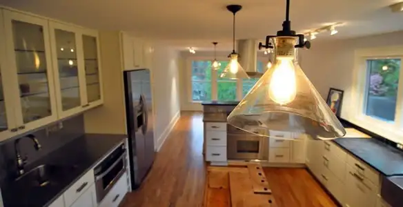 Residential electrician installing modern indoor light fixture in a home in Miami, FL